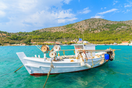 White traditional fishing boat on sea water in Posidonio bay, Samos island, Greece
