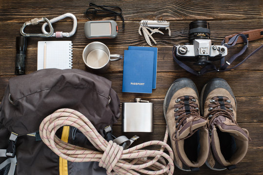 Travel items near backpack on the floor for mountain trip