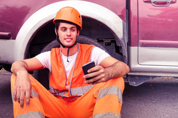 Worker road man having fun taking selfie with modern mobile phone - Portrait of young happy surveyor relaxing oudoor - Concept of hard work pause and modern technology - Smiling builder with helmet