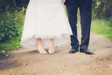 Fototapeta premium feet of bride and groom, toned image