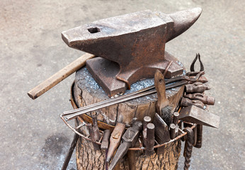Old anvil with blacksmith tools on the outdoors
