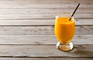 Healthy pumpkin smoothies with spices and nuts on rustic  table