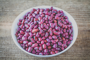 Adzuki bean or red bean in white bowl on wood background