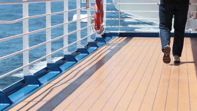 Man walks by on cruise ship deck blue ocean water HD 7831