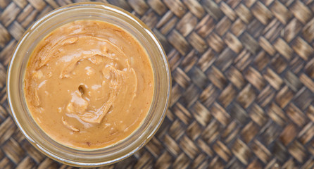 Peanut butter in a mason jar over wicker background