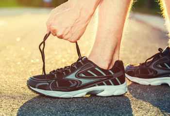 Naklejka premium Male runner tying his shoes