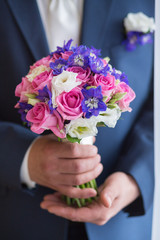 groom hold wedding bouquet in hand