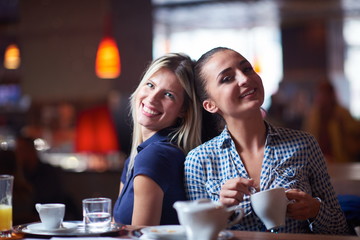 girls have cup of coffee in restaurant