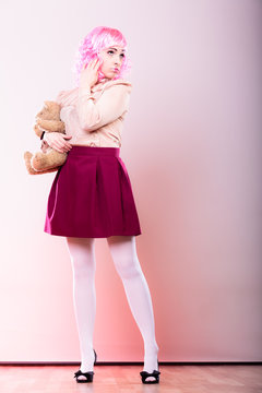 childlike woman with teddy bear toy