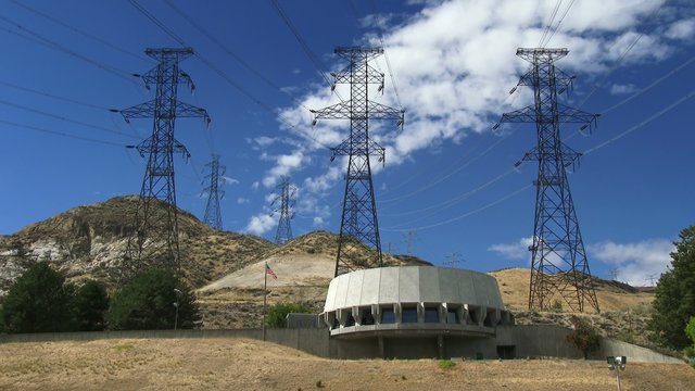 The visitor center sits on a bluff above Grand Coulee Dam with power lines in eastern Washington state, 4K, Ultra HD