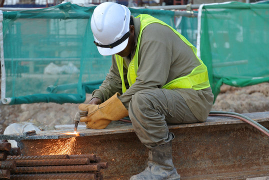 Construction workers cutting metal using blowtorch at the construction site