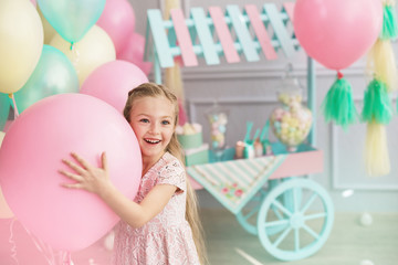 Portrait of a little girl smiles and holds a big balloon