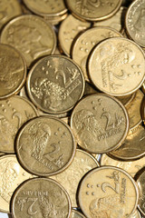 Pile of gold Australian two dollar coins with aborigine male stamped scattered.