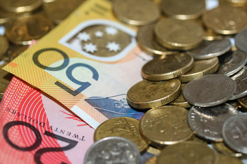 Close up of Australian money, twenty and fifty dollar notes and gold and silver coins scattered on pile.