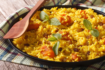 Sweet pilaf with saffron and dried fruit close up. horizontal
