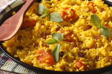 Sweet yellow rice with raisins and dried apricots macro. horizontal
