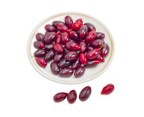 Berries of cornus on saucer on a light background