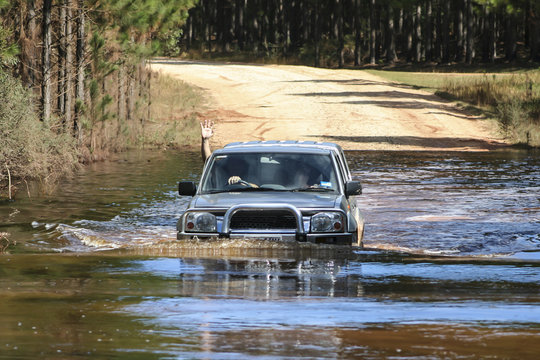 4x4 driver waving while crossing a driver over flood waters.