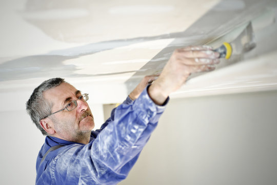 Man filling holes with spatula