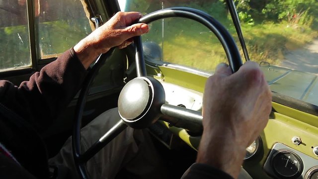Old car goes through the countryside.