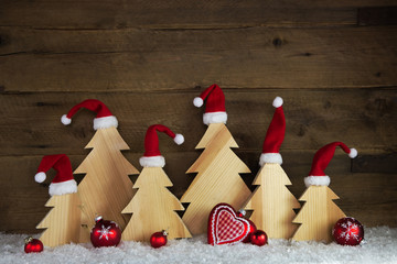 Weihnachten mit Humor. Handgemachte Weihnachtsbäume aus Holz mit Nikolausmütze als Hintergrund...