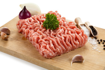 Raw minced pork on cutting board and vegetables 