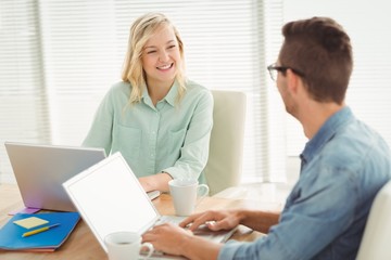 Obraz premium Smiling woman looking at man while sitting on chair 