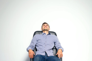 Business man sitting on chair and posing isolated on white background