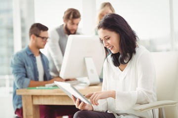 Happy woman with headphones using digital tablet 