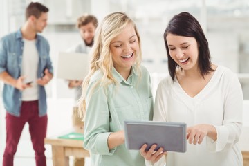Smiling women using digital tablet 