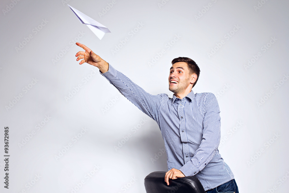 Wall mural Business man throwing a paper plane on white background