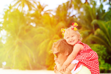 Happy father and cute little daughter at beach