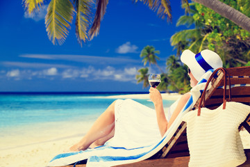 woman drinking wine on tropical beach