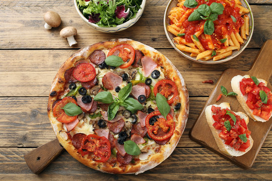 cibo mediterraneo pizza pasta con pomodoro e insalata sfondo rustico