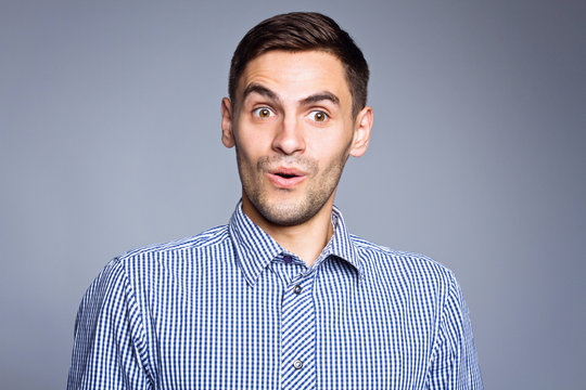 Surprised face of business man on gray background