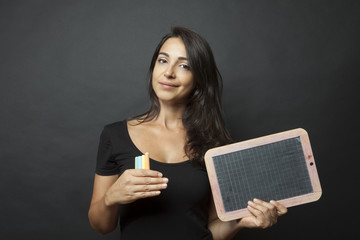Bellissima ragazza con espressione sorridente mostra una lavagna 