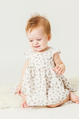 little girl sitting on the sheep's clothing