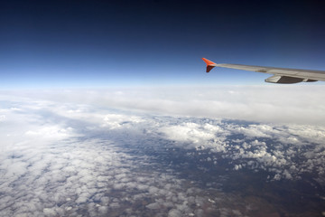 Fototapeta premium Wing of the Airbus above the clouds in the sky, view from above the clouds, flying over clouds in plane, space, weather and climate for flying, the atmosphere and the stratosphere, meteorology.