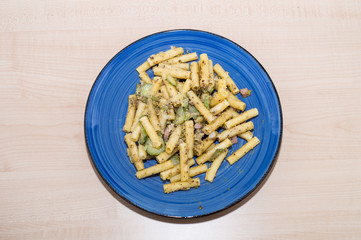 Piatto di pasta con pesto di pistacchi, pancetta e zucchine 