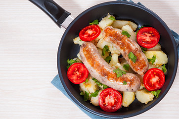 Potatoes with sausages in a frying pan