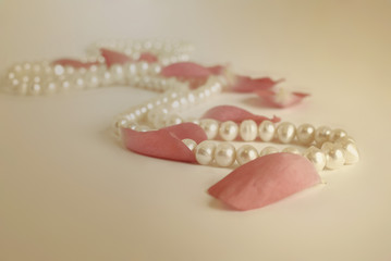 pearls necklace and rose petals vintage style background 