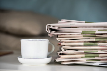 Stack of newspapers with a cup of coffee

