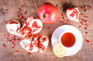 Pomegranate fruits with hibiscus drink on wooden background.