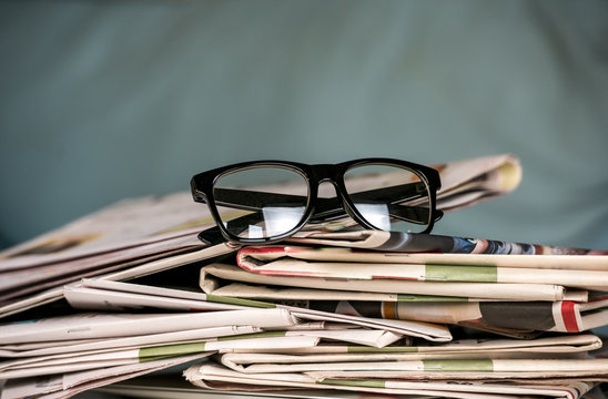 Glasses and newspapers, close-up
