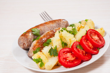 Potatoes with sausages on plate
