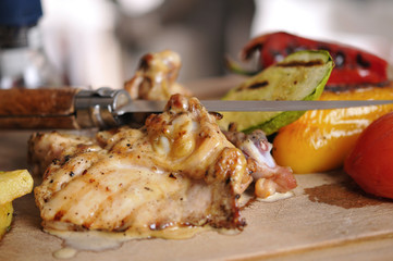 Chicken barbecue with fried potato and red wine on wood table