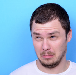 Obraz premium Portrait of man with dusgusted gesture against blue background