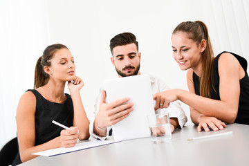 three young business people during meeting working with a computer tablet in office