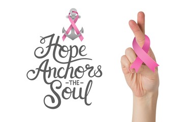 Composite image of crossed fingers with breast cancer ribbon