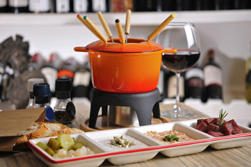 Fondue with appetizer and hot sauce with red wine